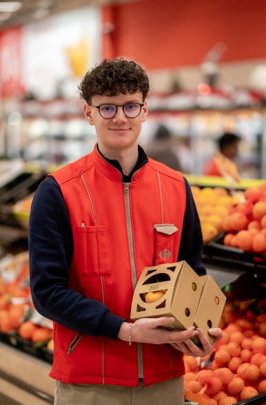 Employé commercial Carrefour Market au rayon fruit et légume