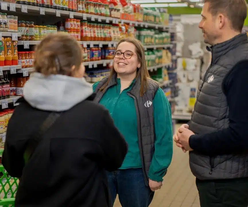 Deux collaborateurs Carrefour en train de discuter avec une cliente dans un rayon