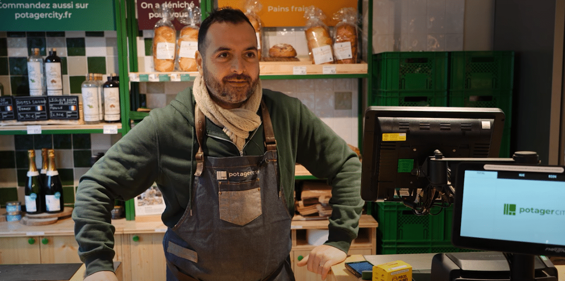 Photo de Christophe, locataire-gérant derrière le comptoir de son magasin Potager City