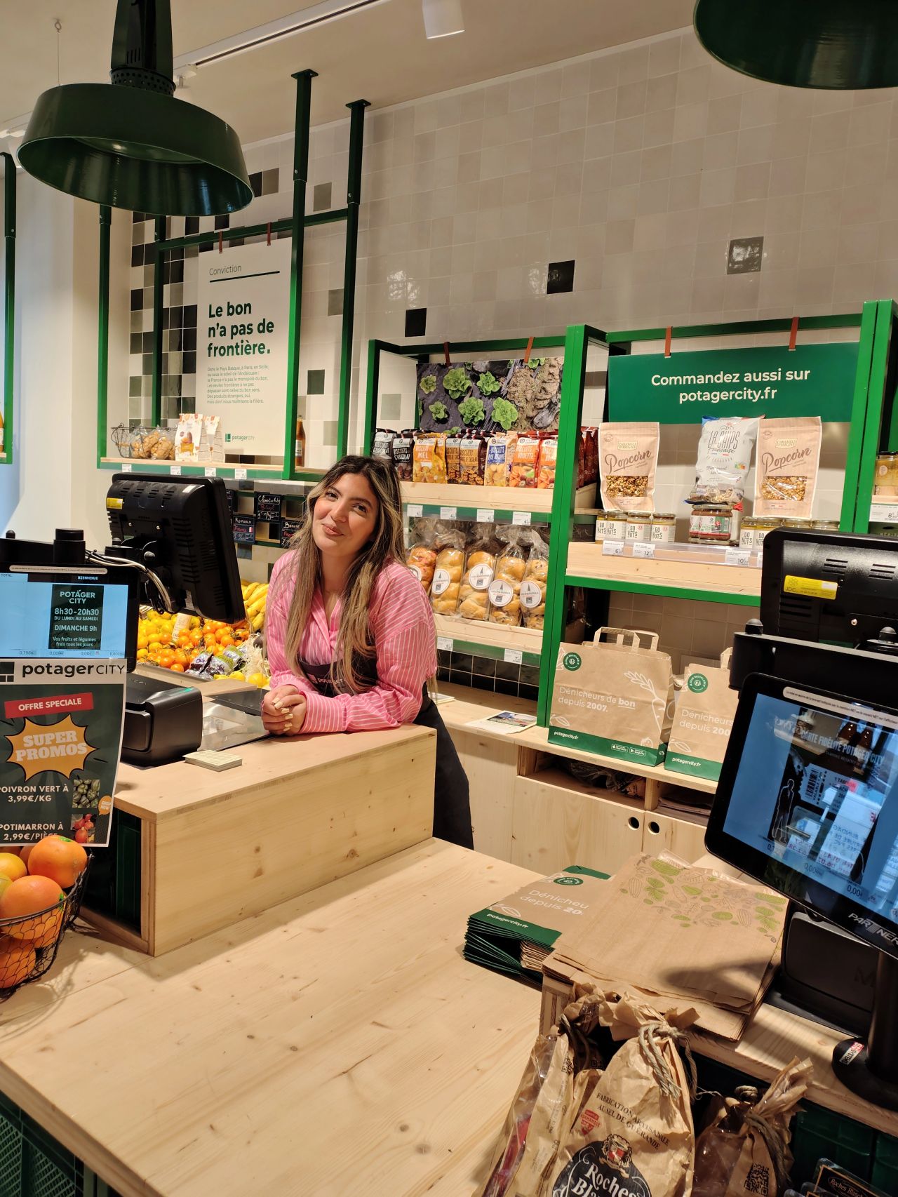 Photo d'Amanda Yahia Cherif, locataire-gérante, au comptoir d'un magasin Potager City